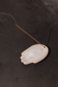 a pair of white gloves on top of a black floor next to an object with a string