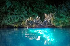 the inside of a cave with blue water