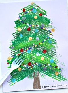 a christmas tree made out of crayon paper with a fork sticking out of it