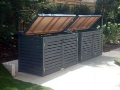 two large storage bins sitting next to each other on a sidewalk in front of a house