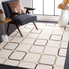 a living room area with a chair and rug on the floor next to a window