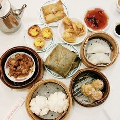 a table topped with lots of different types of food on plates next to cups and saucers