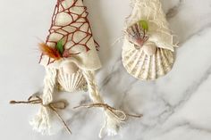 two seashells are sitting on a marble counter top, one is decorated with red and white fabric