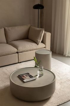 a living room with a couch, coffee table and magazine on the floor in front of it