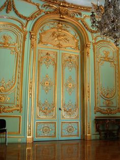 an ornately decorated room with blue walls and gold trimmings on the doors