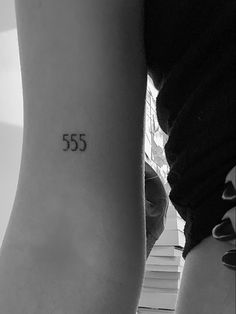 two people with tattoos on their arms and one has the number 555 written on it