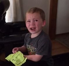 a young boy holding a piece of yellow paper