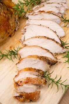 sliced pork on a cutting board with herbs