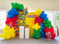 an arch made out of lego blocks with balloons on the front and sides, along with other decorations