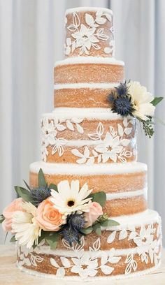 a three tiered cake with flowers on top