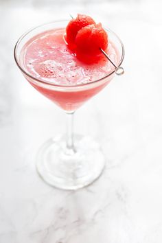 a pink cocktail garnished with two cherries