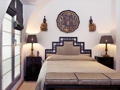 a large bed sitting under two lamps in a bedroom