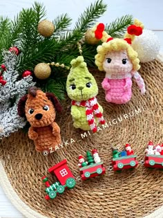 three small crocheted animals sitting on top of a mat next to a christmas tree