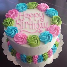 a birthday cake decorated with flowers and the words happy birthday written in frosting on it