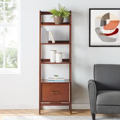 a living room with a gray chair and book shelf