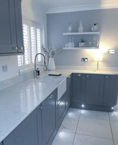 a kitchen with white counter tops and gray cabinets