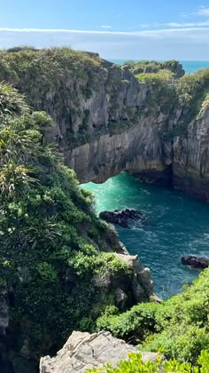 the water is blue and green near some cliffs