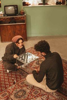 two people sitting on the floor playing chess