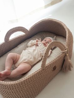 a baby laying in a wicker bassinet