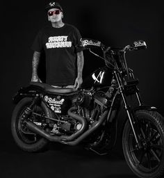 a man standing next to a motorcycle on a black background