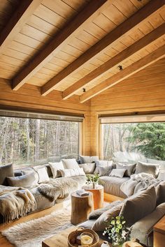 a living room filled with lots of furniture next to a large window covered in wood