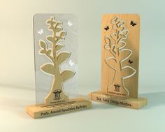 two wooden plaques with flowers and butterflies on them, one is engraved in the shape of a tree