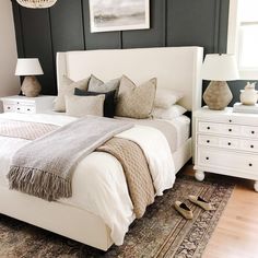 a white bed sitting in a bedroom on top of a wooden floor