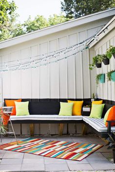 an outdoor seating area with colorful pillows and rugs