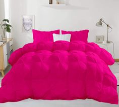 a bright pink comforter set with white pillows