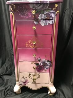 a pink and gold dresser with flowers painted on it