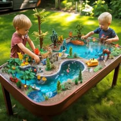 two young boys playing with toys on a table in the yard, near a pond