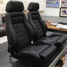 two black leather seats sitting on top of a table