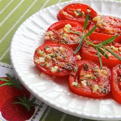 tomatoes with herbs and garlic on a white plate