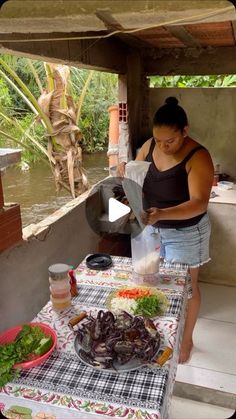 a woman standing at a table filled with food