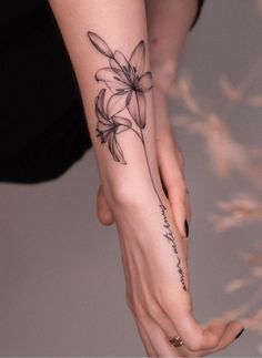 a woman's hand with a flower tattoo on it