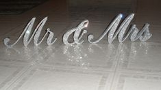 the letters mr and mrs are made out of crystal beads on a white tile floor