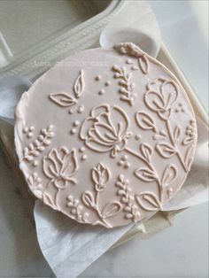 a decorated cake sitting on top of a piece of wax paper next to a box