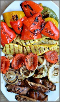 grilled vegetables on a white plate with peppers, onions, and mushrooms in the middle