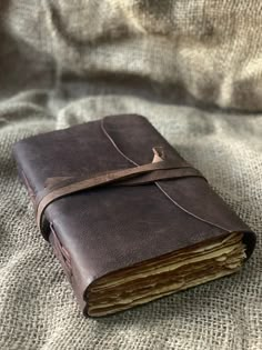 a brown leather journal sitting on top of a bed