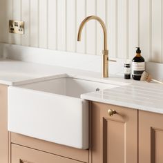 a white sink sitting under a faucet next to a wooden counter top in a kitchen