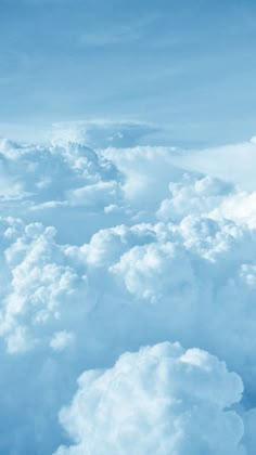 the view from an airplane looking down on clouds and blue sky with white fluffy clouds