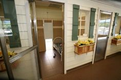 the inside of a house with green shutters and flowers on the window sill