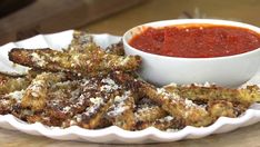 some fried food on a white plate with sauce