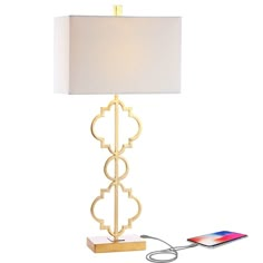 a table lamp with a phone plugged into the charger and charging cord attached to it