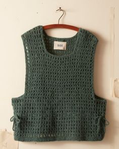 a green knitted top hanging on a wall