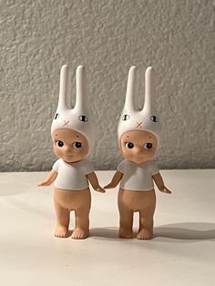 two toy rabbits are standing next to each other