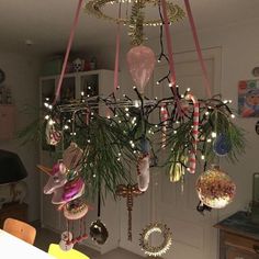 a chandelier with ornaments hanging from it's sides and lights on the top