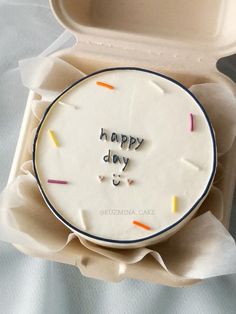 a birthday cake with the words happy day written on it in a white box that is open