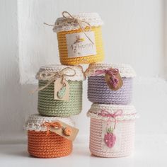 four crocheted jars are stacked on top of each other