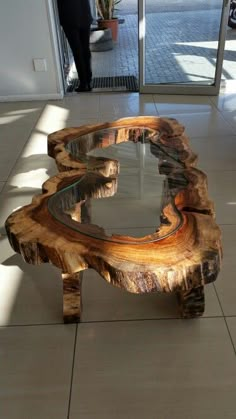 a wooden table with glass top sitting on the floor